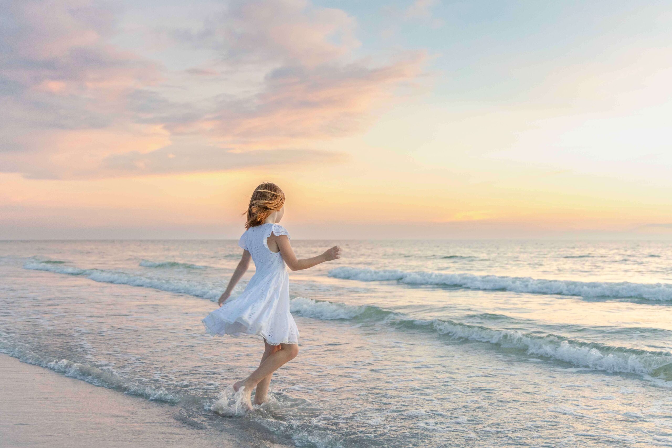 girl twirling in dress on beach- tampa family photographer