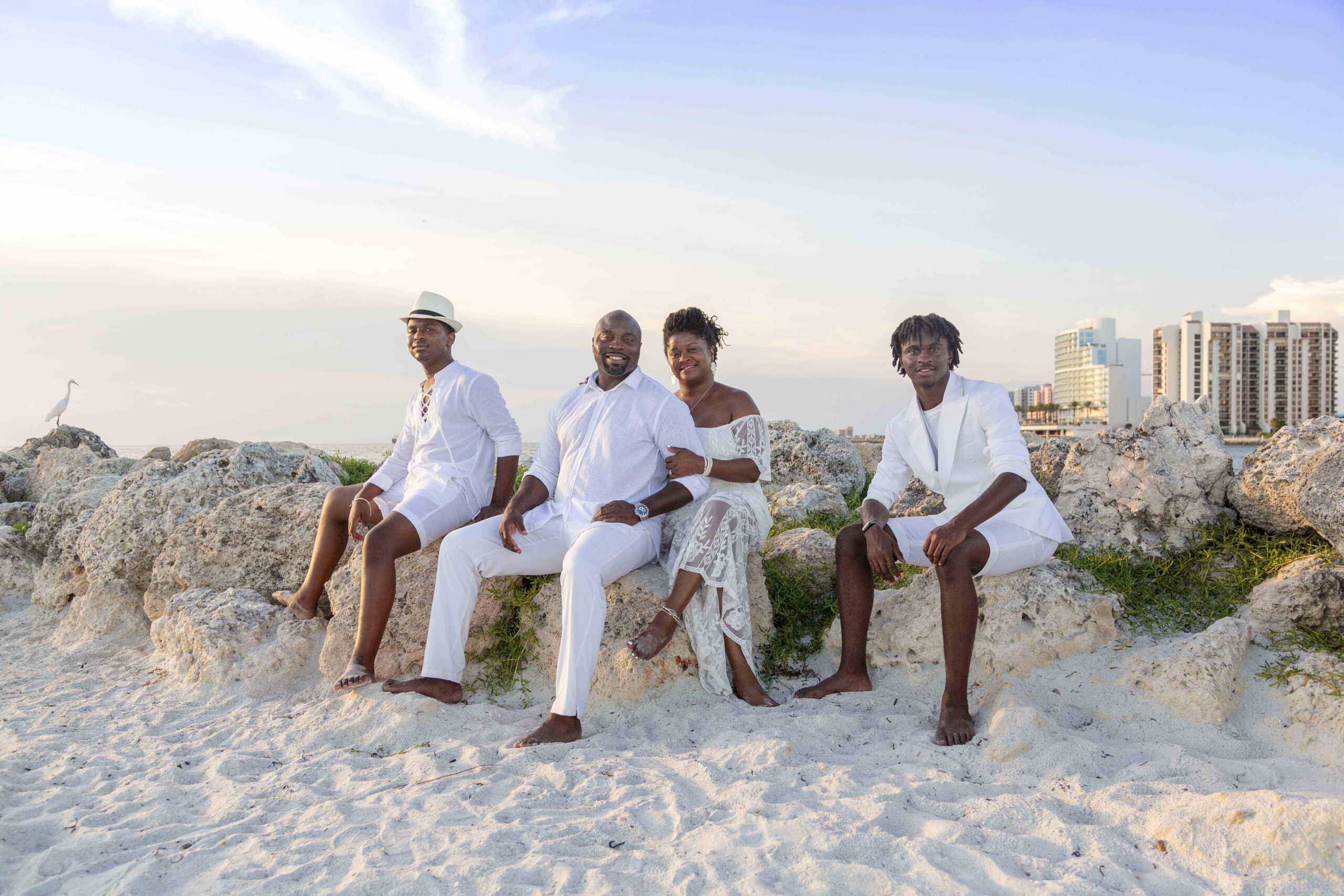 family sitting on rocks at beach- tampa family photographer