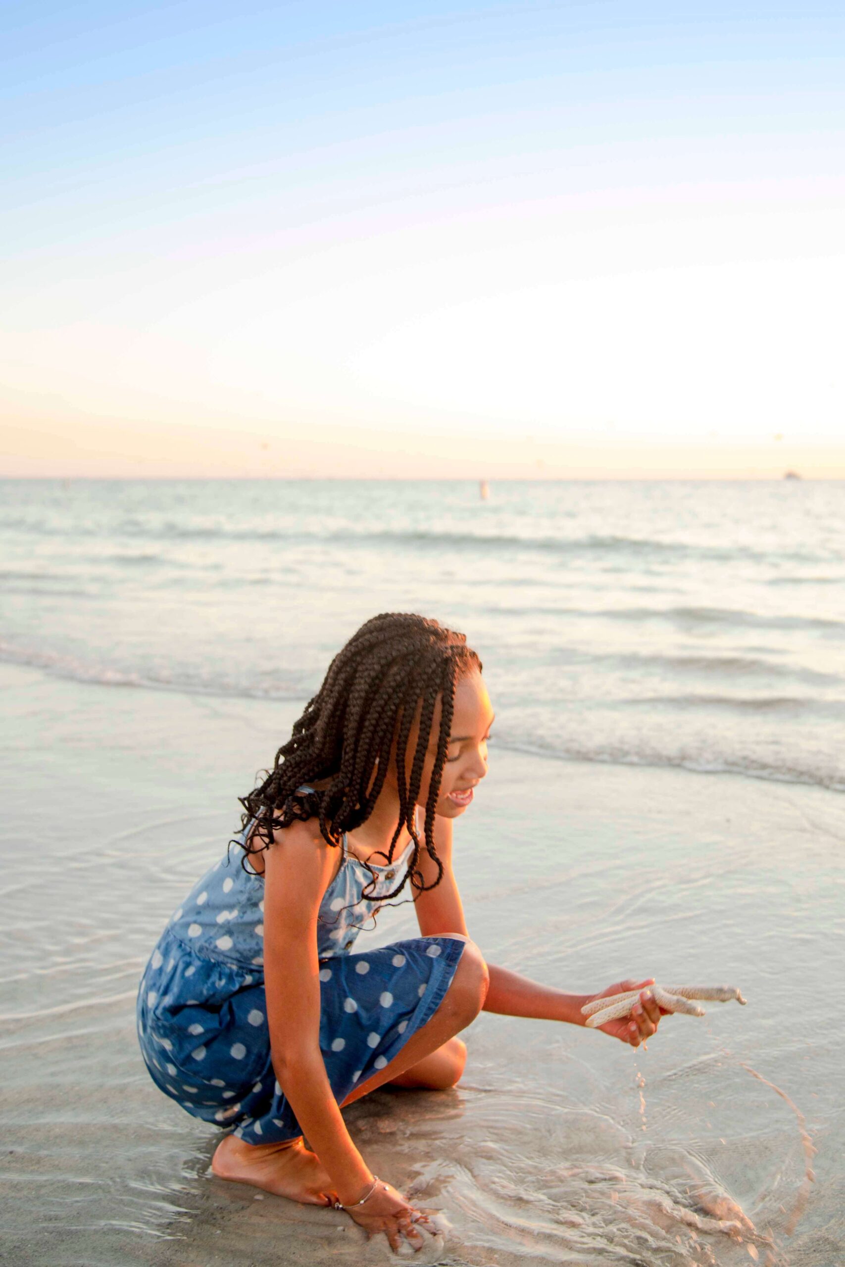 black girl on beach holding starfish- tampa florida photographer