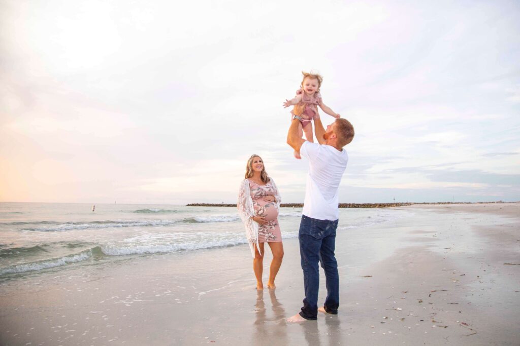 dad tossing child in air on beach with tampa florida photographer