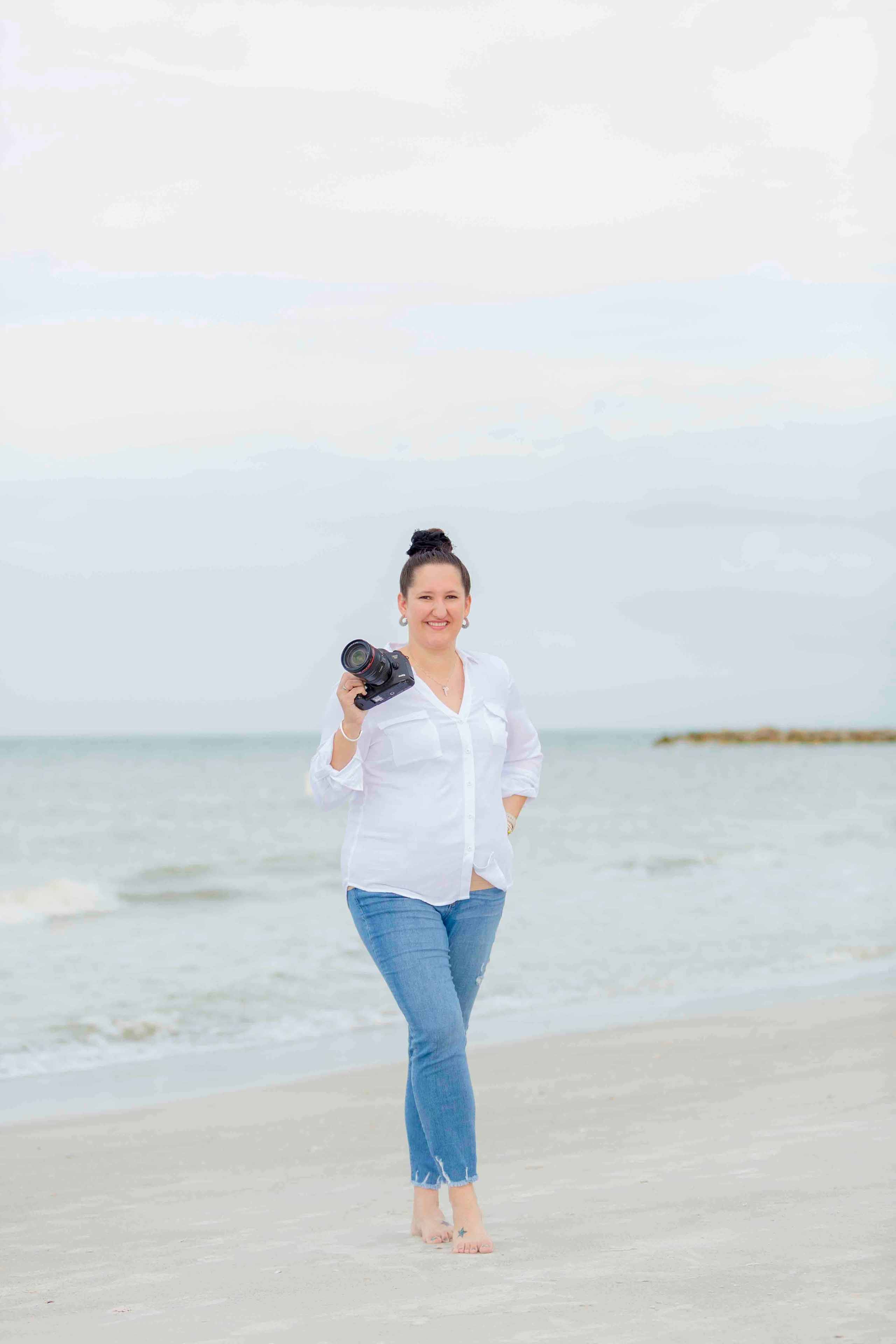 tampa photographer smiling on beach holding camera